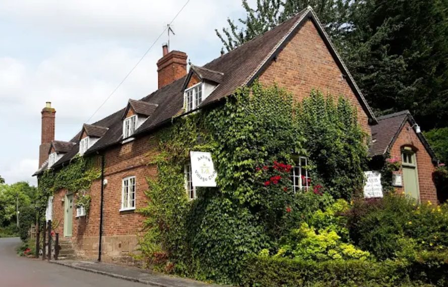 Ashow Village Club: the ivy-covered red-brick club building on the village lane, with its hanging sign and dormer windows